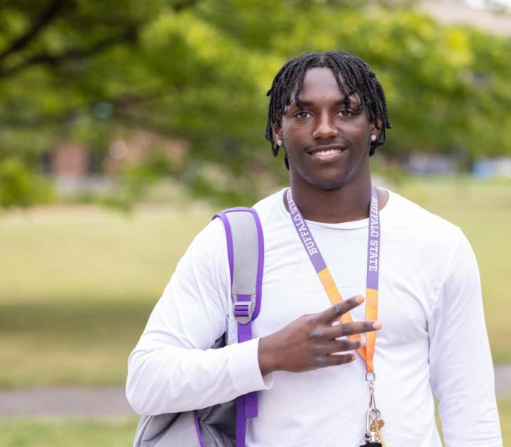 A male student wearing a Buffalo State lanyard
